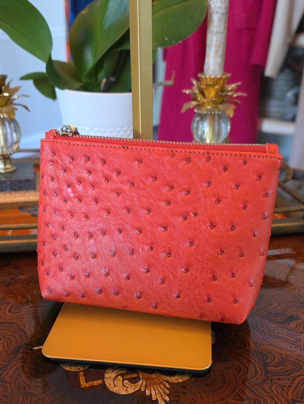 Orange faux-ostrich pouch features a textured quill-dot finish NWOT